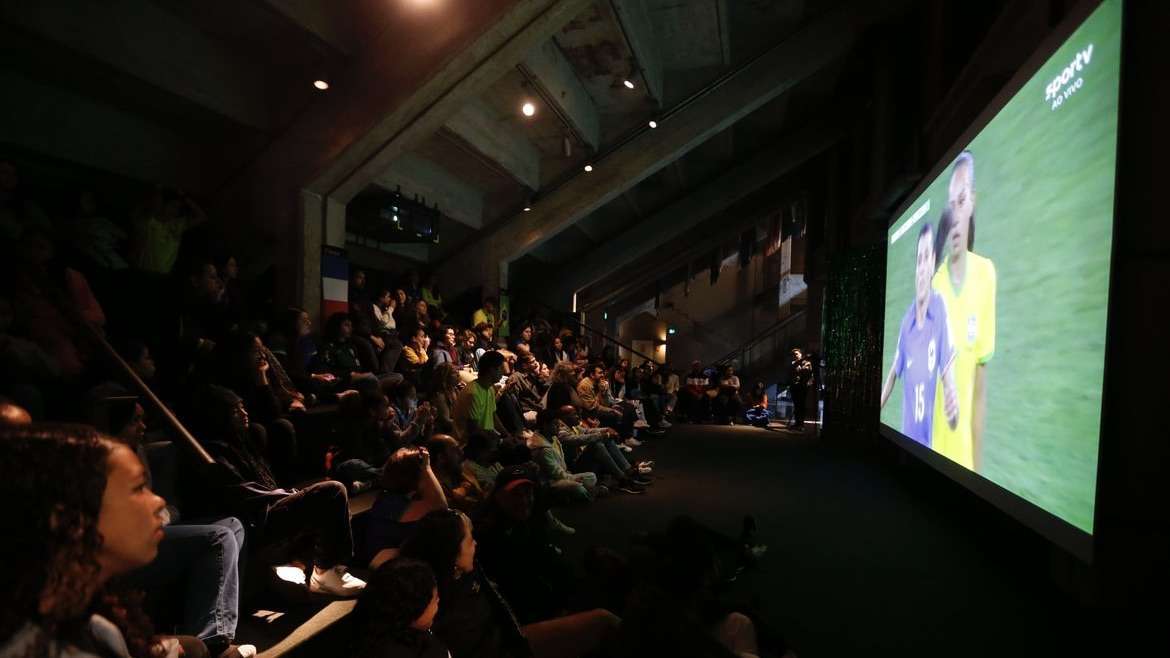 Torcedores Lamentam Derrota do Brasil diante da França enquanto Museu do Futebol Exibe a Partida.