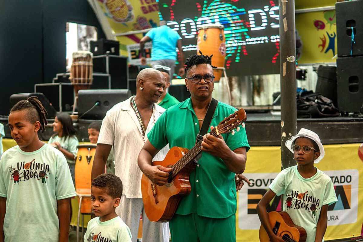 A banda Viola de Doze celebrou, em 16 de janeiro de 2026, os 10 anos do projeto Violinha Boa com apresentação no Pelourinho, em Salvador. O evento reuniu alunos, público e convidados, destacando a participação ativa das crianças no palco. A iniciativa promove acesso à música e formação cultural, consolidando-se como ferramenta de inclusão social, embora ainda demande maior estrutura institucional e mensuração de resultados.