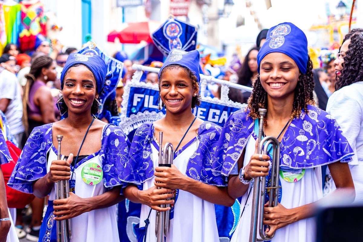 O Afoxé Filhas de Gandhy inicia em 15 de setembro de 2026 o segundo ciclo do Arte das Yabás, em Salvador. O projeto oferece gratuitamente cursos de percussão e clarins para mulheres durante dez meses, além de rodas terapêuticas quinzenais. Rose Ratinha comandará a formação em percussão e Geanderson Brito ministrará as aulas de clarins. A iniciativa é financiada pela Política Nacional Aldir Blanc na Bahia.
